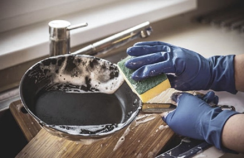 A person cleaning a non-stick cooking pan