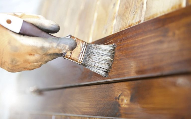 A person applying varnish